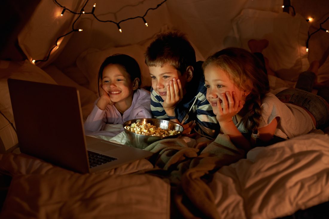 movie-time-in-the-pillow-fort-three-young-children-using-a-laptop-in-a-blanket-fort
