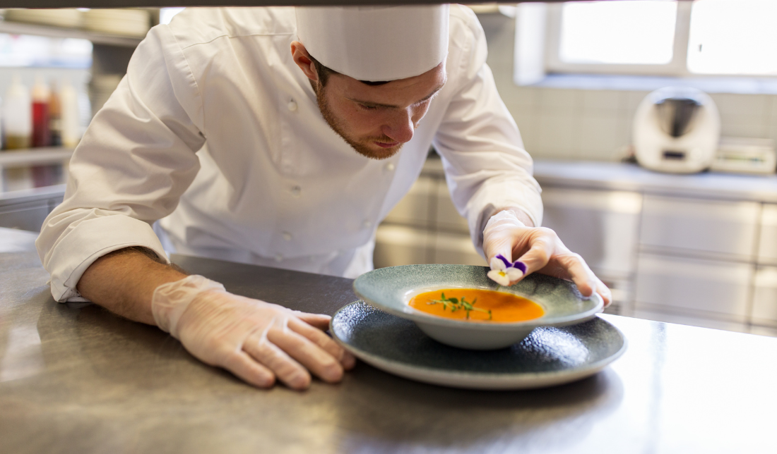 A chef preparing a dish in a professional kitchen