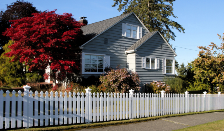 beautifully landscaped house with a white picket fence