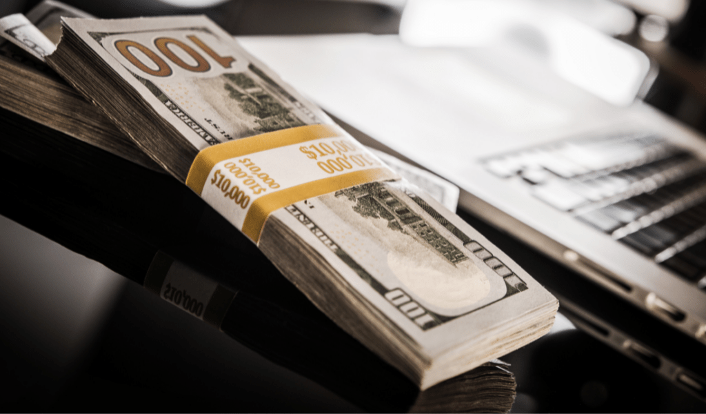 computer with dollar bills stack