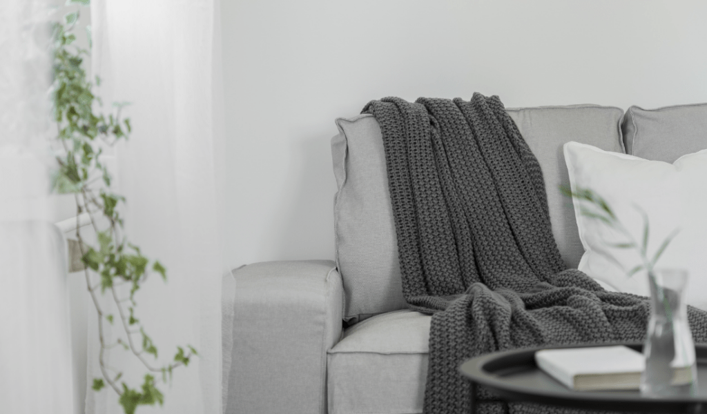 cozy living room with a warm blanket draped over a couch