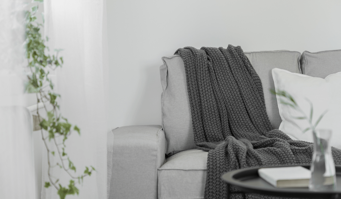 cozy living room with a warm blanket draped over a couch