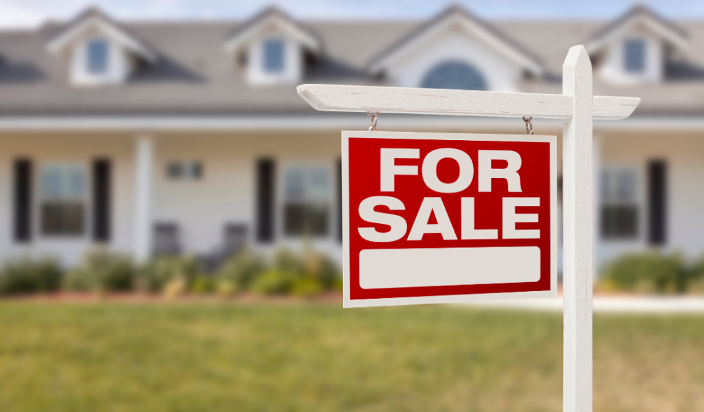 house with a 'For Sale' sign in front