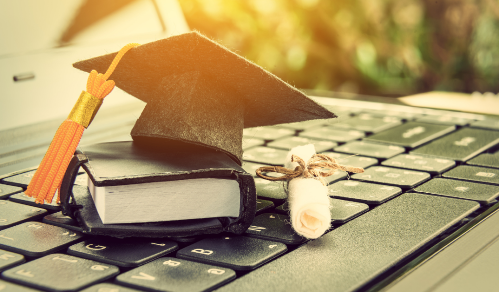 laptop with a graduation cap on the screen, symbolizing education