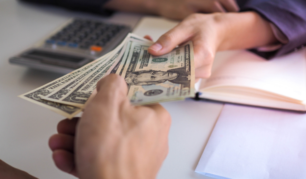 person handing over money to another, signifying investors delivering pledges