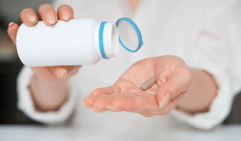 person holding a bottle of nutritional supplements