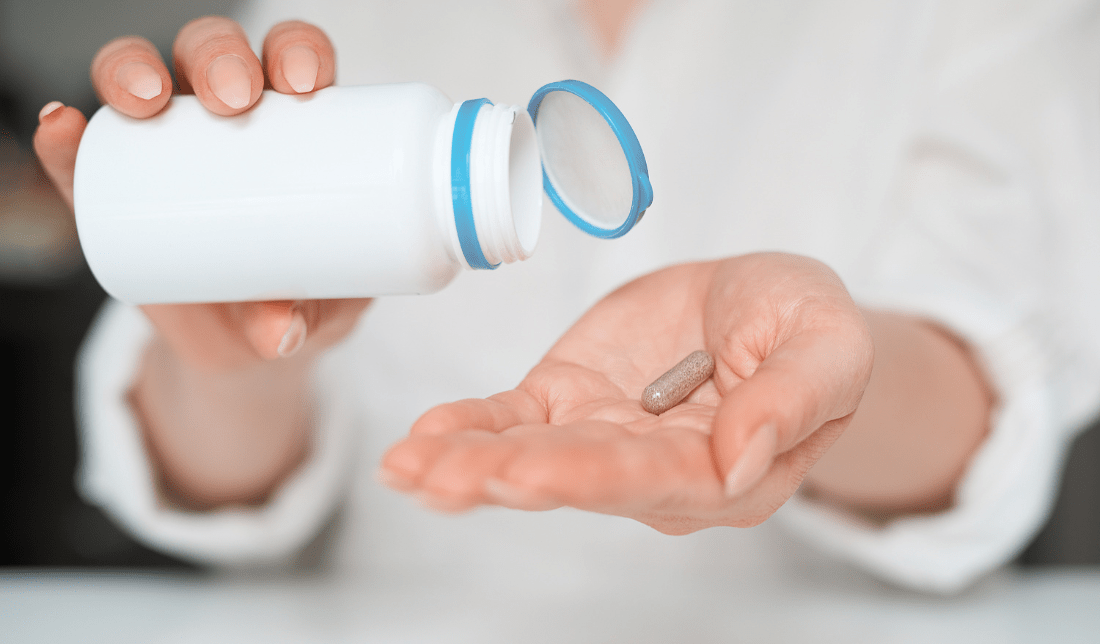 person holding a bottle of nutritional supplements