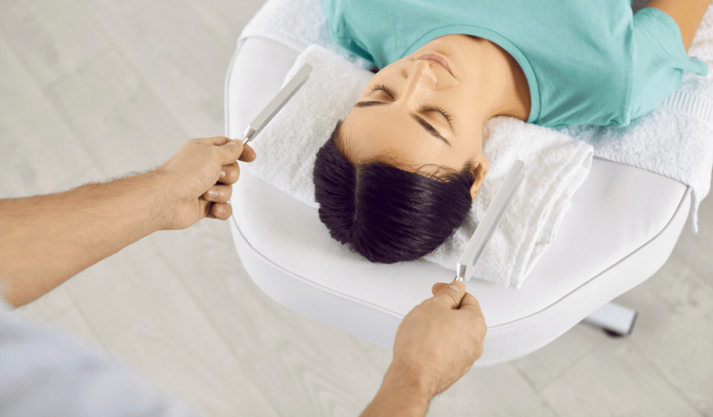 person meditating while holding an energy tuner or fork