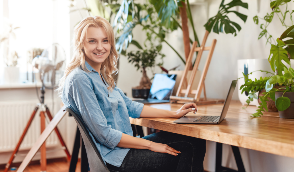 person sitting comfortably and happily in a chair while working on a laptop