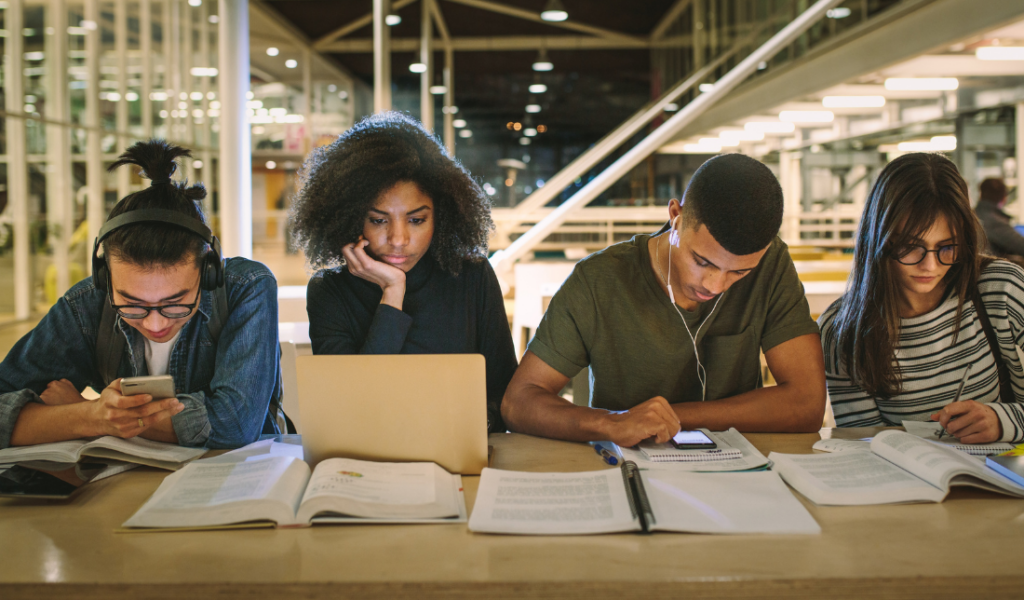 students studying together books laptops