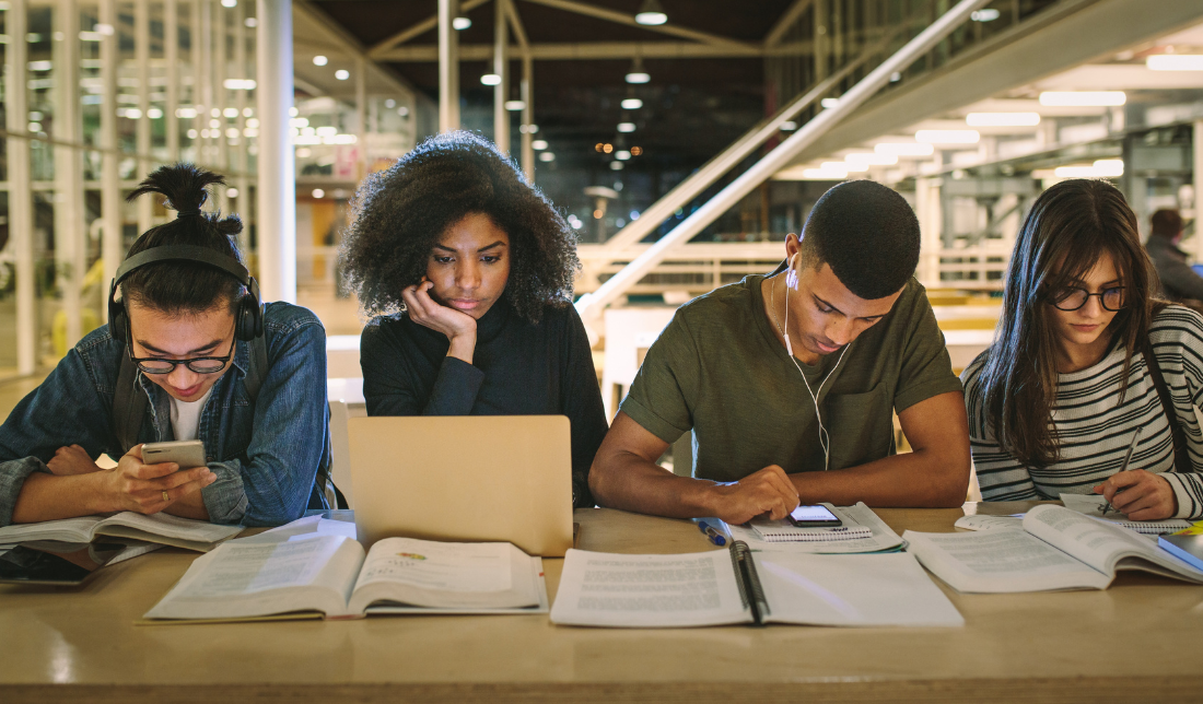 students studying together books laptops