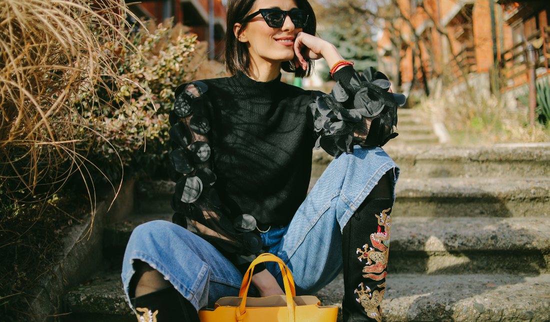 woman carrying a leather bag and wearing leather boots and jewelry