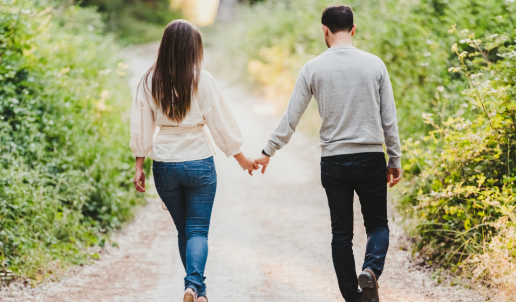 couple holding hands with a backdrop of a bookshelf