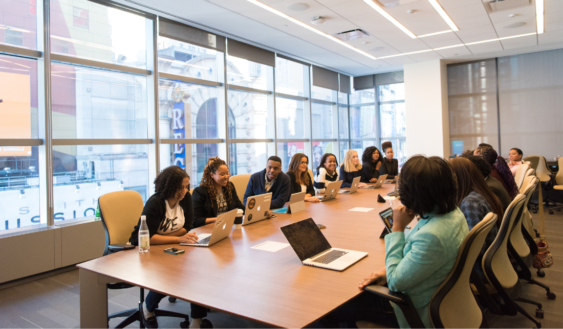 people in a conference room with computers